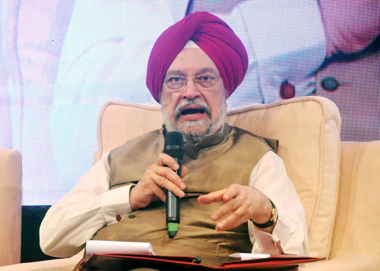 Hardeep Singh Puri in a turban and waistcoat, speaking into a microphone