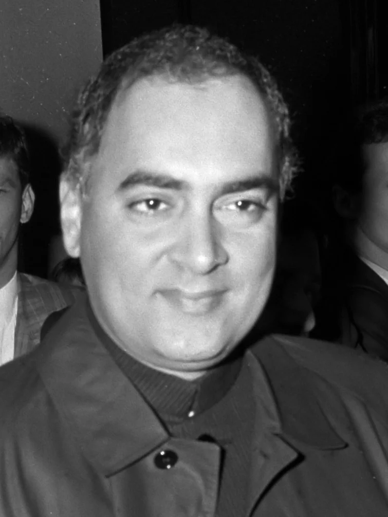Rajiv Gandhi smiling, in a dark high-collared jacket